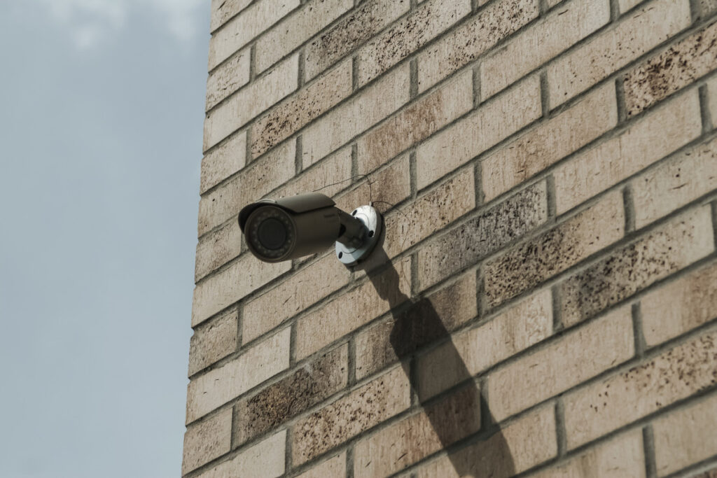 Camere de supraveghere amplasate pe un perete exterior al unei cladiri din caramida.