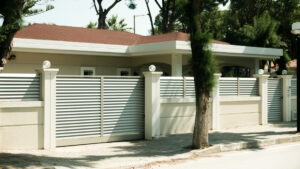 O casa frumoasa cu un gard alb si o poarta alba, dotata cu un sistem de automatizare pentru confort sporit.