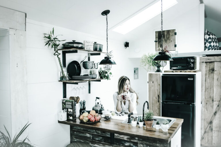 Intr-o bucatarie moderna, o femeie se bucura de moment, avand o electrovalva de apa alaturi.