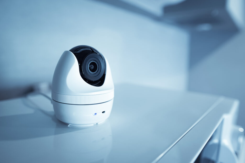 Camera de supraveghere alba amplasata pe un blat alb, oferind un aspect modern si elegant.