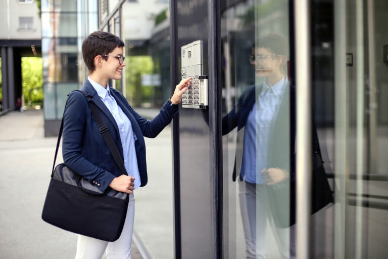 O femeie foloseste un videointerfon cu VTM pentru un acces mai usor.